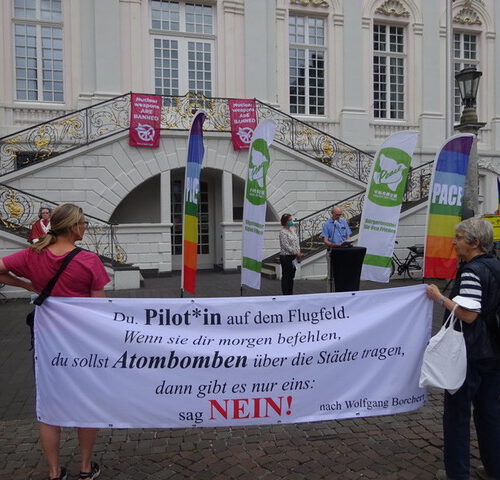Du, Pilot*in auf dem Flugfeld - Kundgebung vor dem Alten Bonner Rathaus (2021) zum Flaggentag der "Städte für das Atomwaffenverbot / Mayors for Peace"